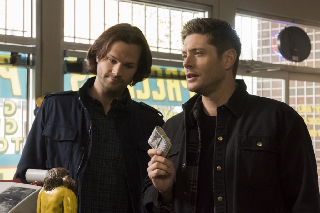 Sam (Jared Padalecki) et Dean (Jensen Ackles) montrant une liasse de billets