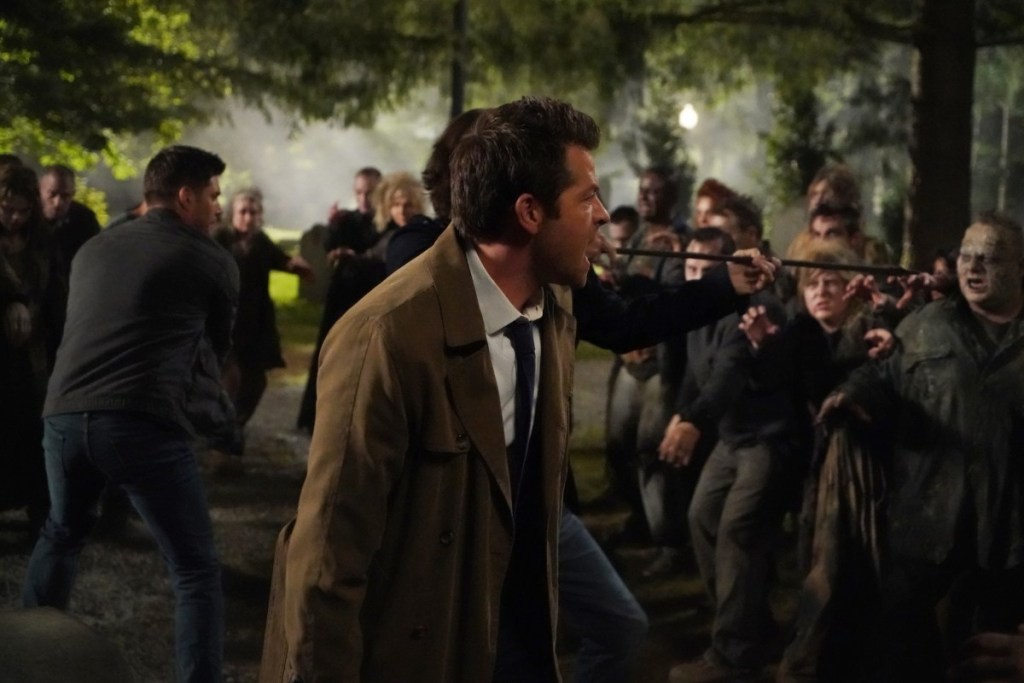 Castiel (Misha Collins), Dean Winchester (Jensen Ackles) et Sam Winchester (Jared Padalecki) tenant à distance les zombies