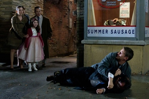 Dean (Jensen Ackles) plaquant un homme au sol, devant des badauds