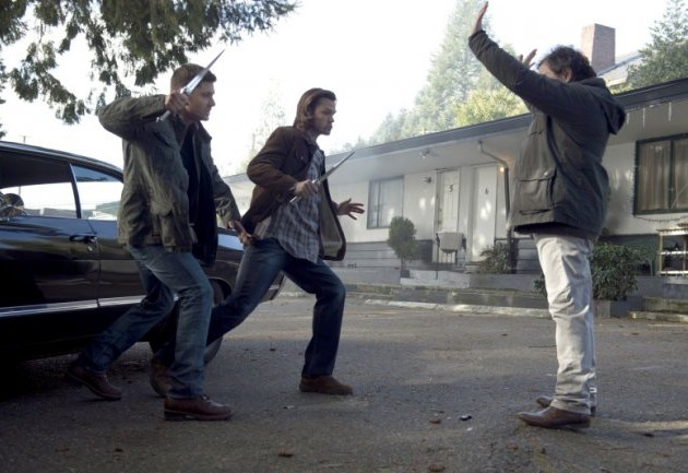 Dean (Jensen Ackles) et Sam (Jared Padalecki) face  Metatron (Curtis Armstrong) mains en l'air
